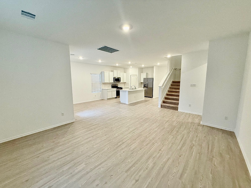 1724 Four Waters Loop Georgetown, TX 78628 - Photo 9 of 38 Living Room featuring stairs, light wood-style flooring, and recessed lighting