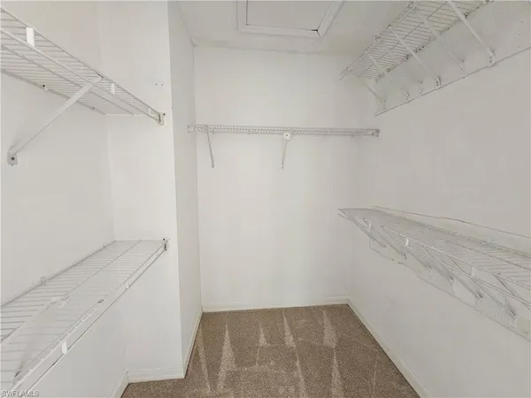 a view of walk in closet with empty racks