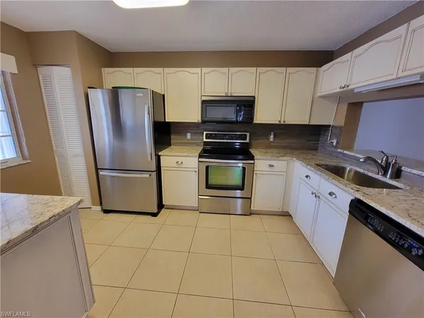 a kitchen with cabinets stainless steel appliances and a counter space