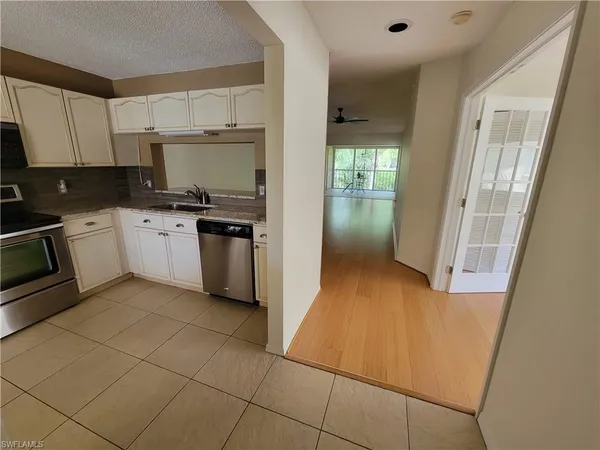 a kitchen with a sink a stove top oven and cabinets