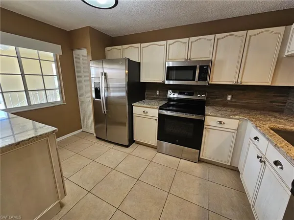 a kitchen with stainless steel appliances granite countertop a refrigerator and a stove top oven