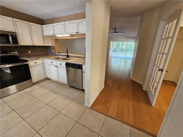 a kitchen with a sink a stove top oven and cabinetry