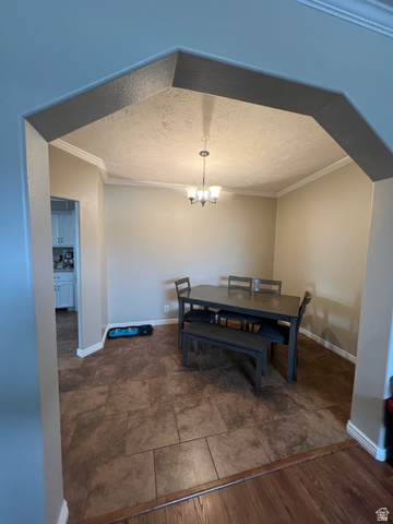 1407 North 1250th Street West Helper, UT 84526 - Photo 11 of 27 Dining area with a textured ceiling, ornamental molding, and a chandelier