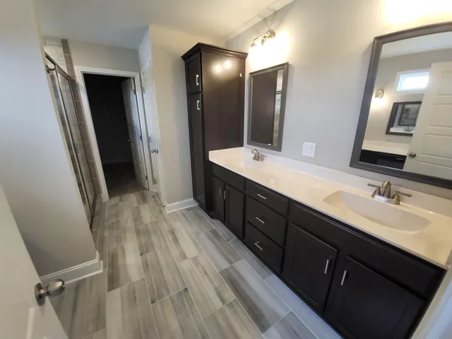 a bathroom with a double vanity sink and mirror