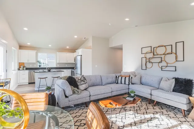 a living room with furniture and kitchen view
