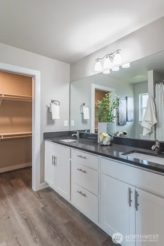 a bathroom with double vanity and a mirror