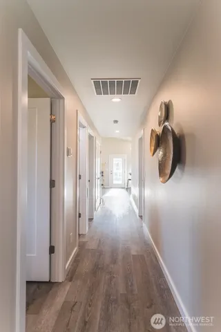 a hallway with sliding door and wooden floor