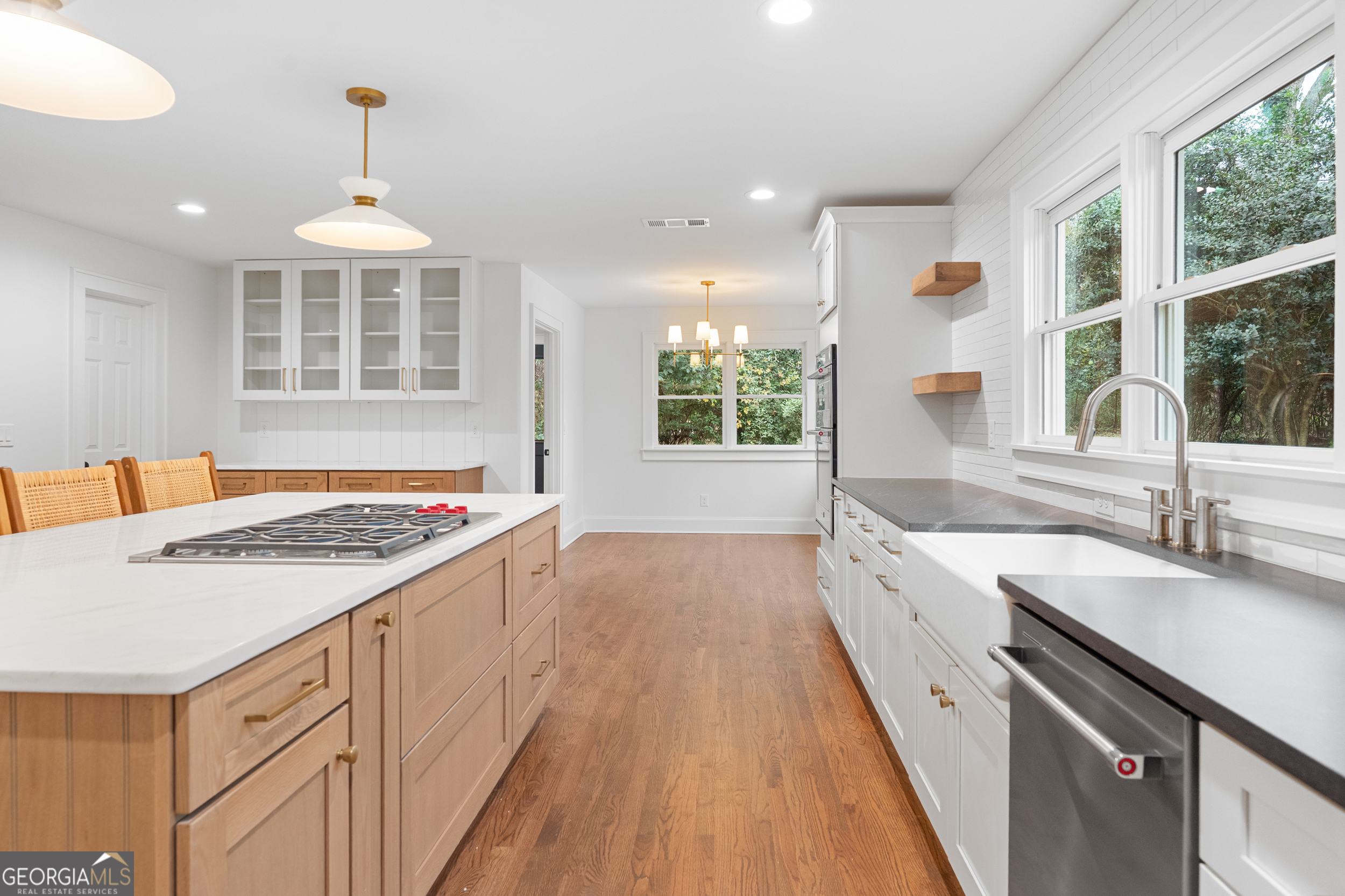 265 Springdale Street Athens, GA 30606 - Photo 8 of 43 a view of a kitchen with kitchen island a sink wooden floor and a large window