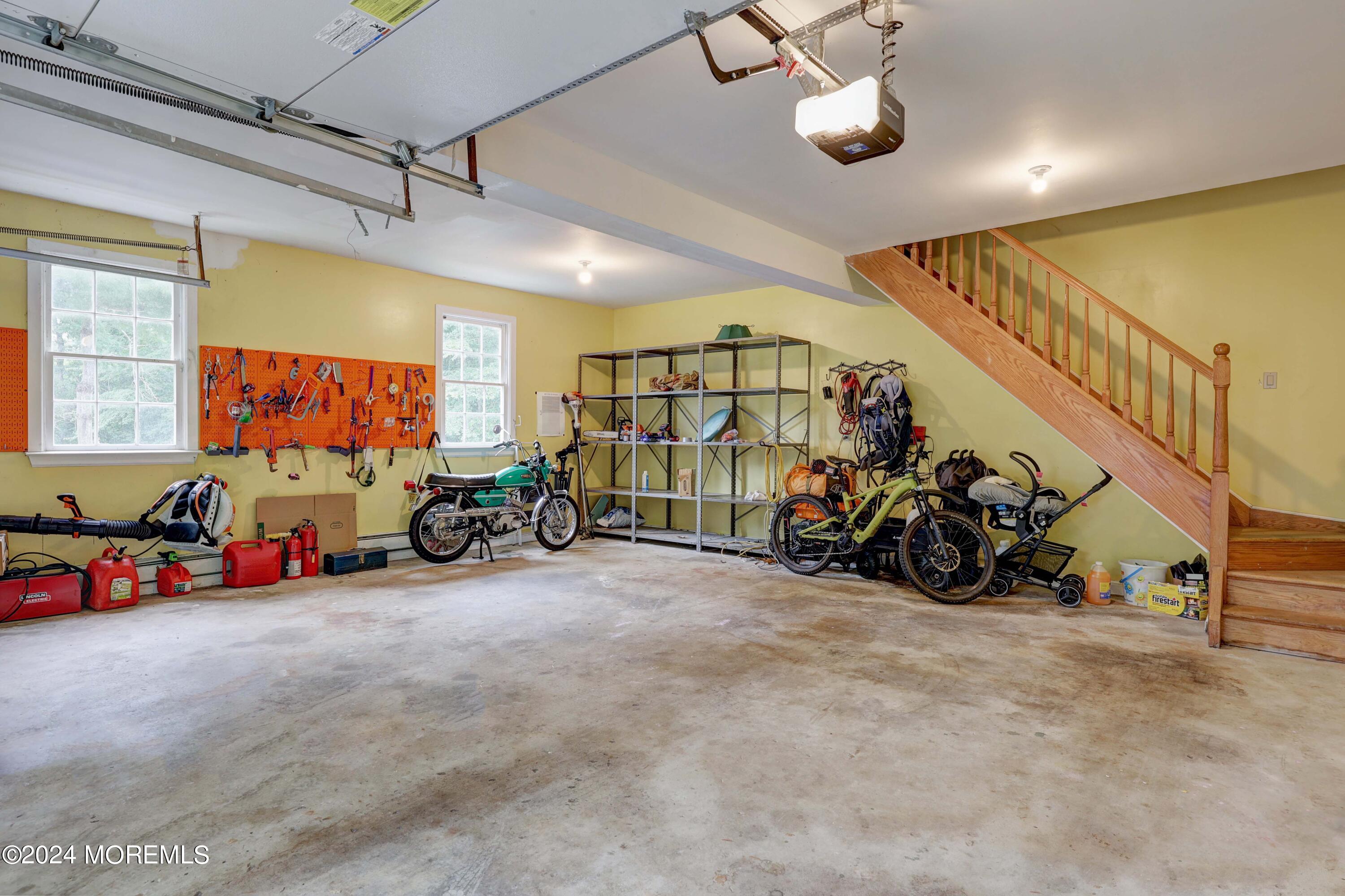 211 Georgia Road Freehold, NJ 07728 - Photo 31 of 41 a view of a garage with a bike and white car