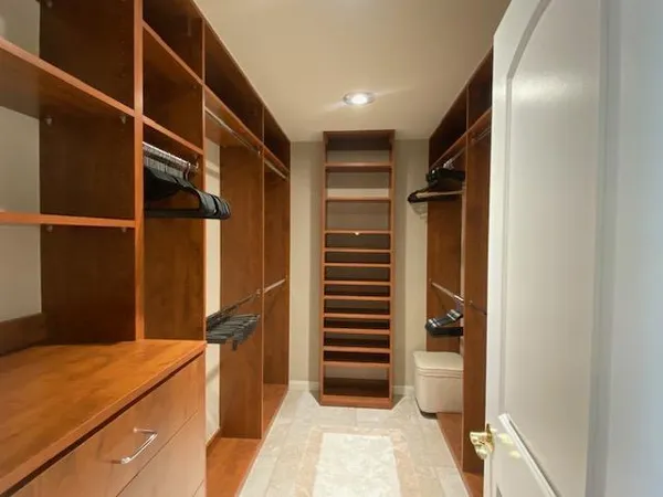 a view of walk in closet with empty racks
