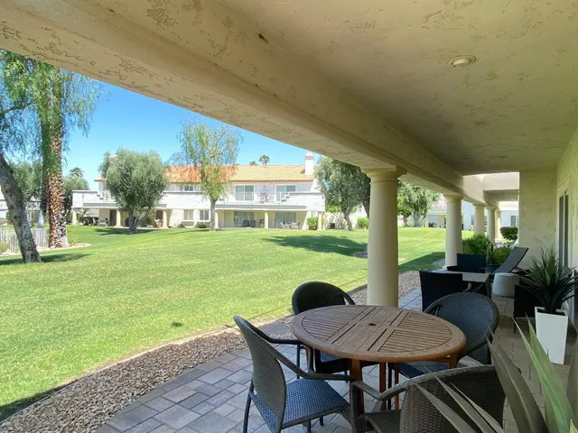 a view of a patio with table and chairs couches with wooden floor and fence