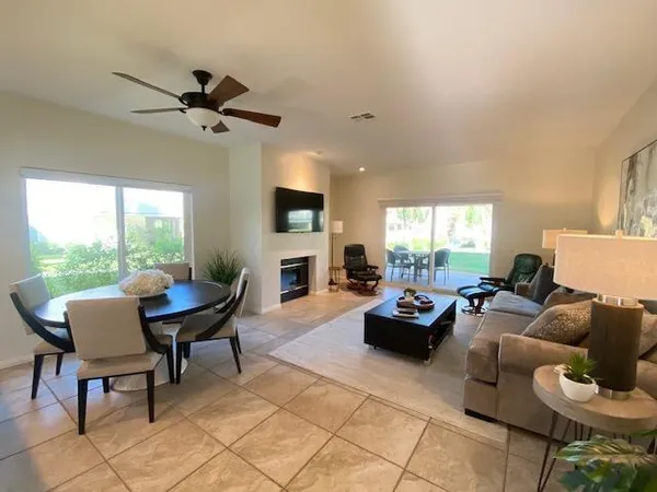 a living room with furniture a fireplace and a large window