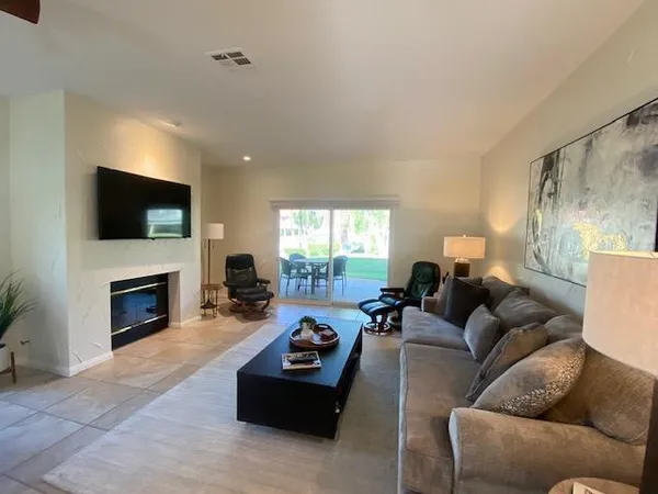 a living room with furniture a fireplace and a flat screen tv