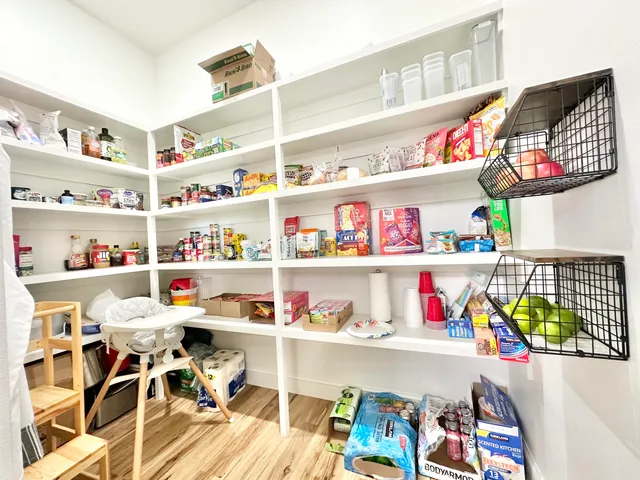 a view of a hallway with wooden floor and a bathroom