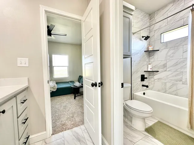 a living room with stainless steel appliances a sink and a flat screen tv