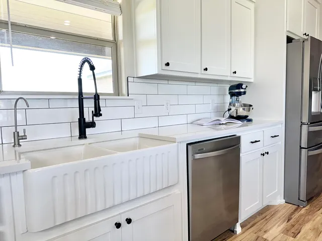 a kitchen with granite countertop a sink stove and cabinets