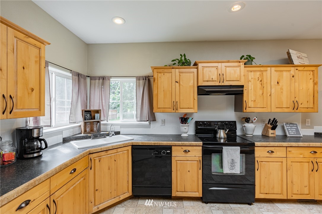 2065 East Pole Road Everson, WA 98247 - Photo 17 of 40 a kitchen with granite countertop a sink stove and cabinets