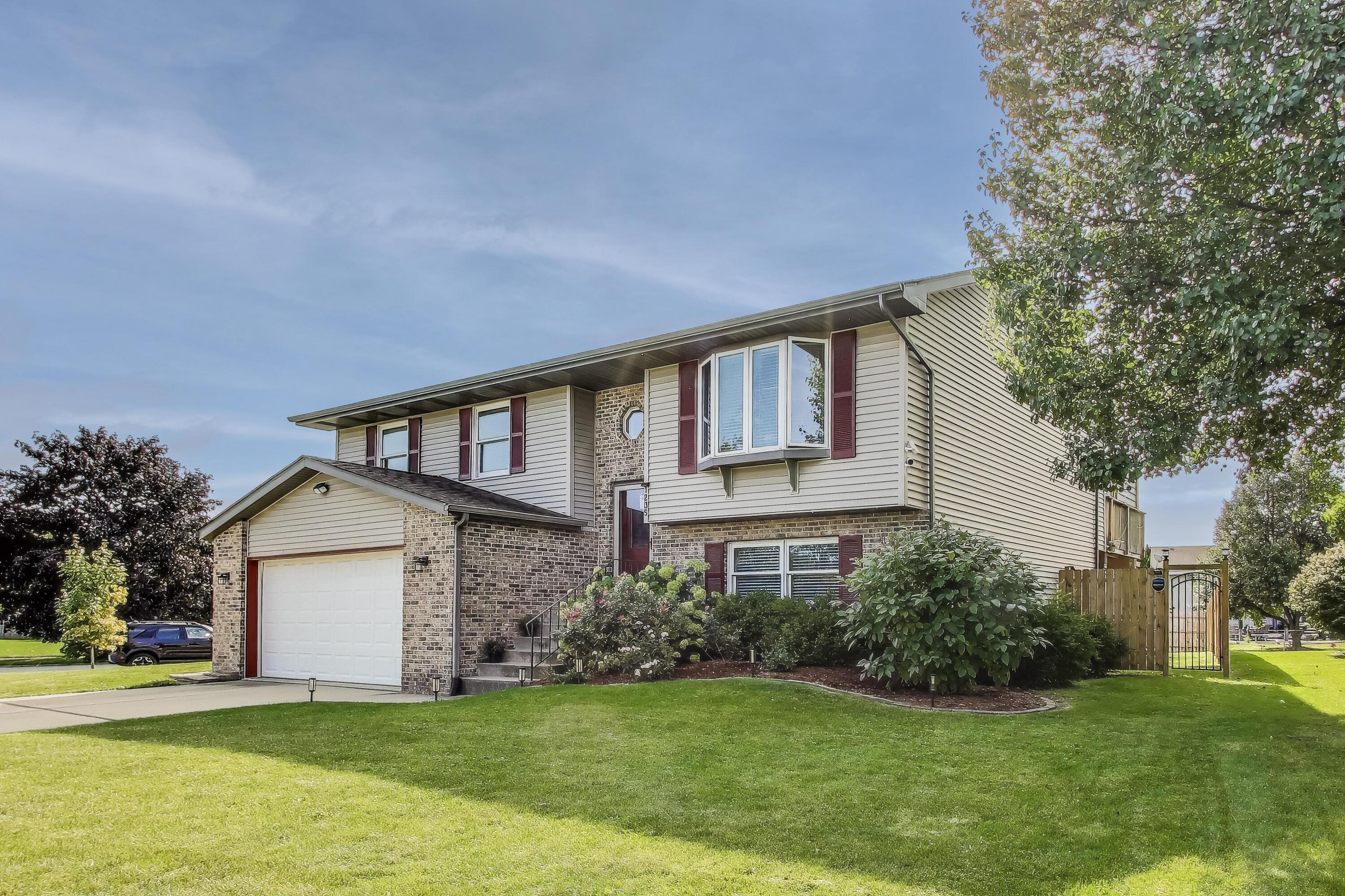 1235 West 99th Avenue Crown Point, IN 46307 - Photo 3 of 54 a front view of a house with a yard and garage