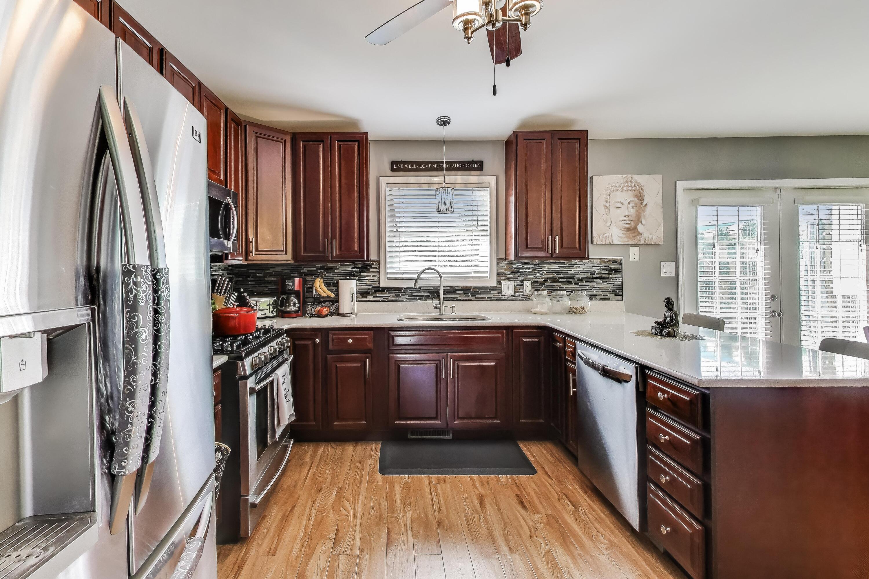 1235 West 99th Avenue Crown Point, IN 46307 - Photo 7 of 54 a kitchen with stainless steel appliances granite countertop a refrigerator a sink dishwasher a stove and a dining table with wooden floor