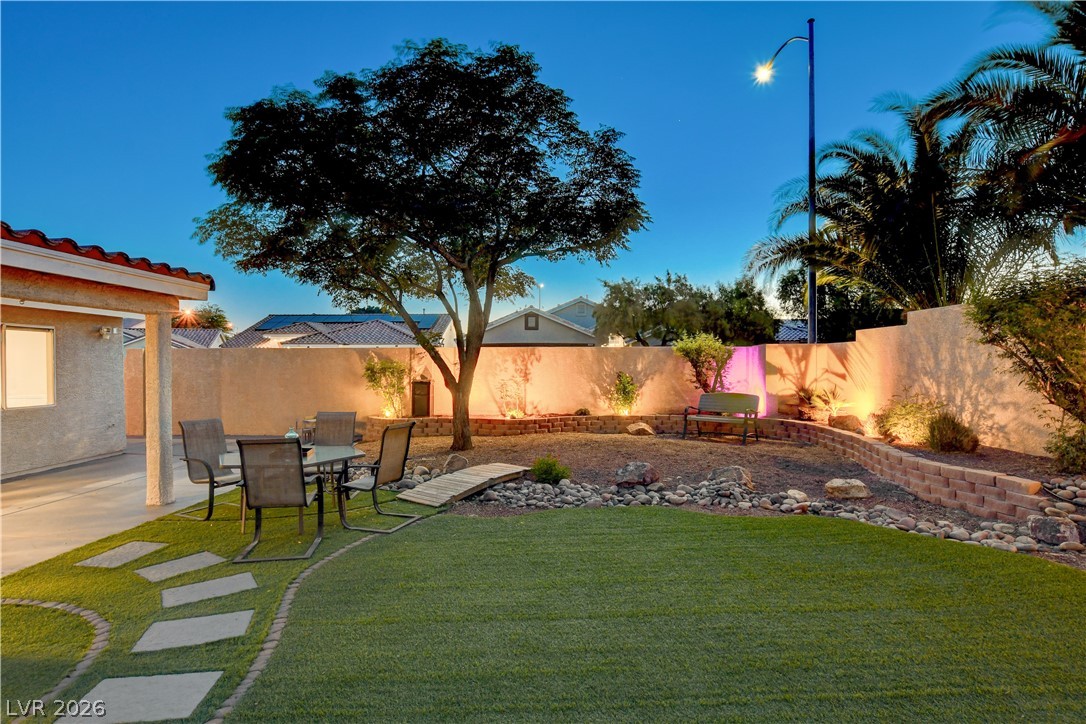 910 Cobblestone Cove Road North Las Vegas, NV 89081 - Photo 29 of 30 Illuminated backyard landscaping provides a serene evening retreat.