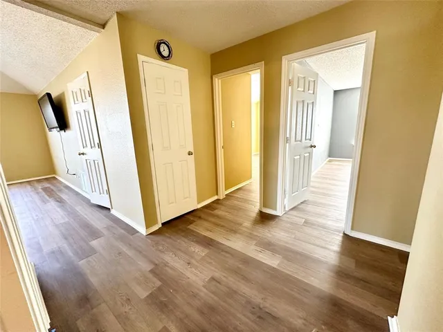 a view of a hallway with wooden floor and stairs