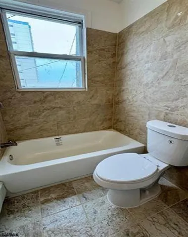 a bathroom with a toilet and a bathtub