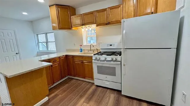 a kitchen with stainless steel appliances a refrigerator a sink and wooden cabinets