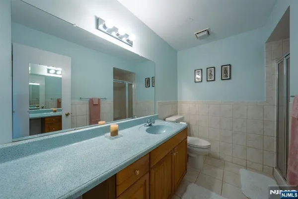 a bathroom with a granite countertop sink a toilet and mirror