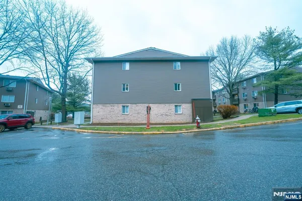 a front view of a house with a garden and trees