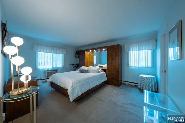 a spacious bedroom with a bed and a chandelier