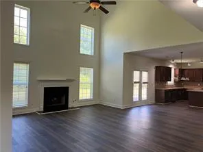 an empty room with wooden floor a fireplace and windows