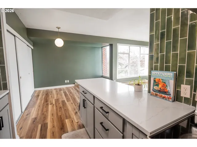 a kitchen with a wooden floor and a large window