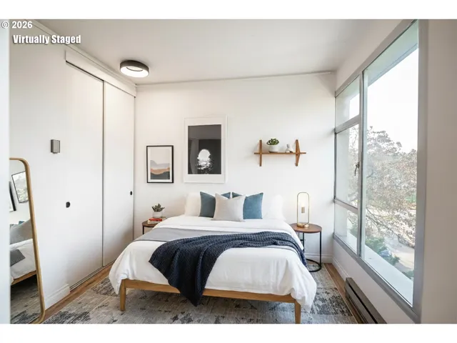 a bedroom with a bed and a large window