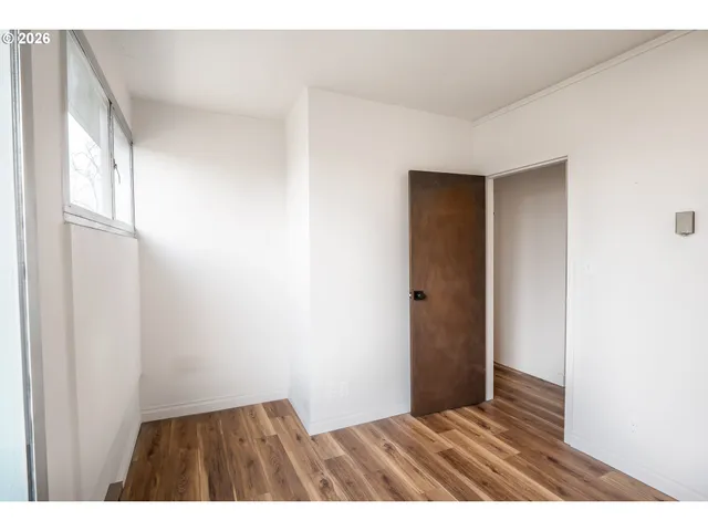 a view of an empty room with wooden floor