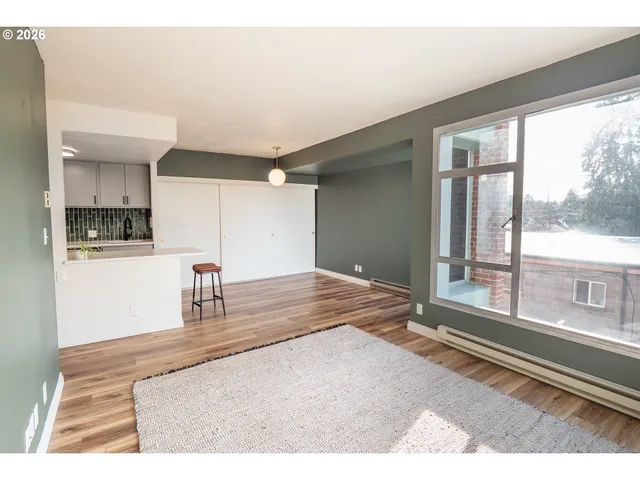 a living room with kitchen furniture and a large window