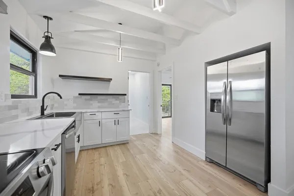 an empty room with windows and ceiling fan