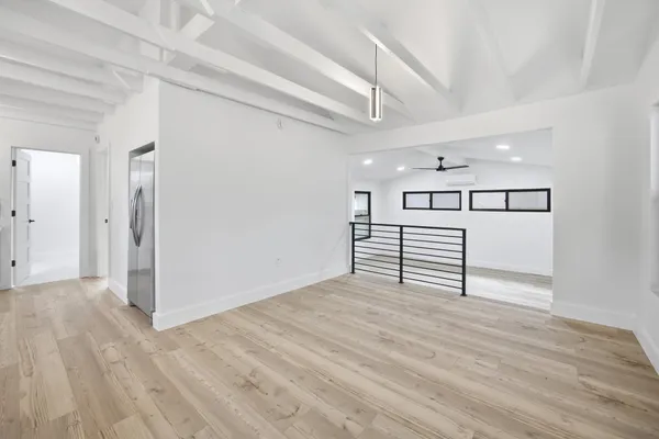a big room with wooden floor closet and windows