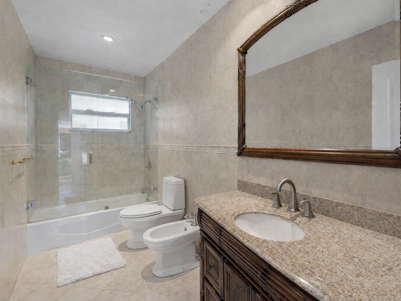5701 Southwest 136th Street Miami, FL 33156 - Photo 17 of 25 a bathroom with a granite countertop sink a toilet a mirror and shower