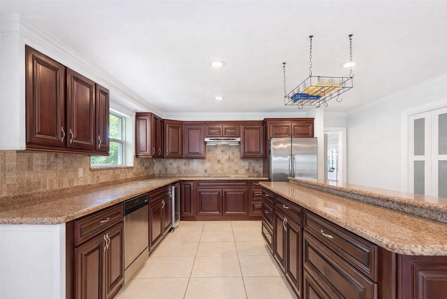 5701 Southwest 136th Street Miami, FL 33156 - Photo 6 of 25 a large kitchen with stainless steel appliances granite countertop a sink and dishwasher a stove with wooden floor