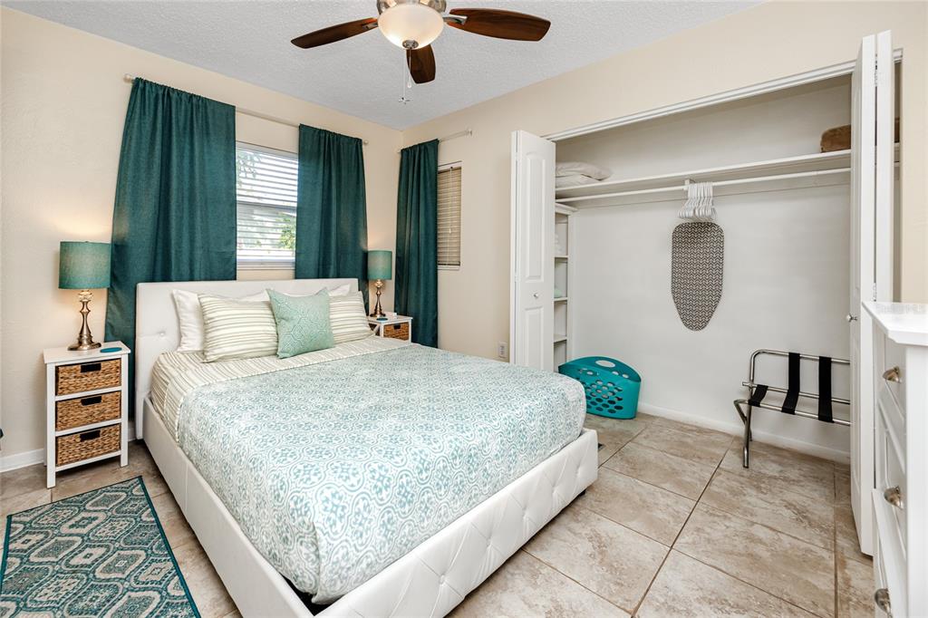 5596 100th Way North St. Petersburg, FL 33708 - Photo 42 of 67 a bedroom with a large bed and a chandelier