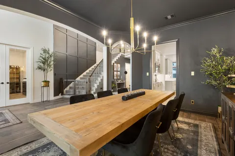 a living room with furniture wooden floor and floor to ceiling windows