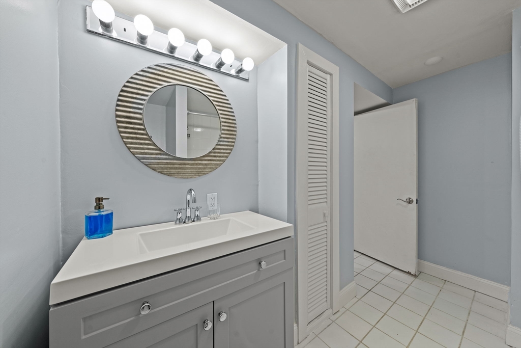 25 Pinedale Road, Unit 1 Boston, MA 02131 - Photo 16 of 21 a bathroom with a sink a mirror and vanity