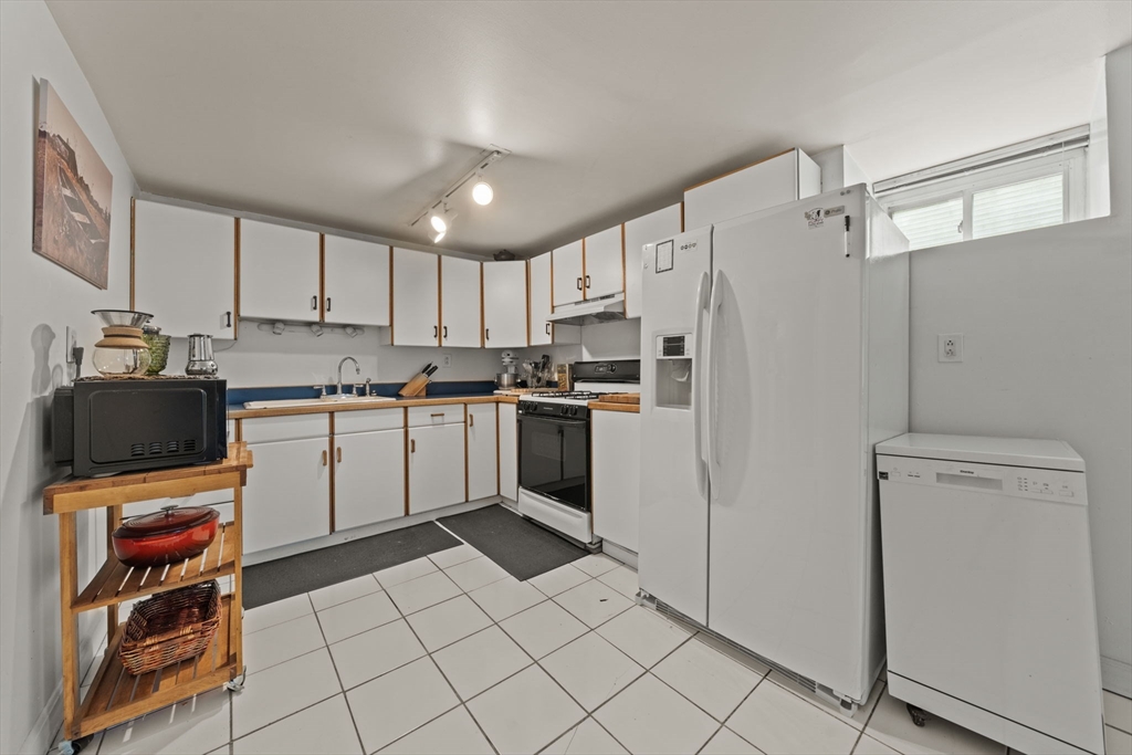 25 Pinedale Road, Unit 1 Boston, MA 02131 - Photo 9 of 21 a kitchen with white cabinets and white appliances