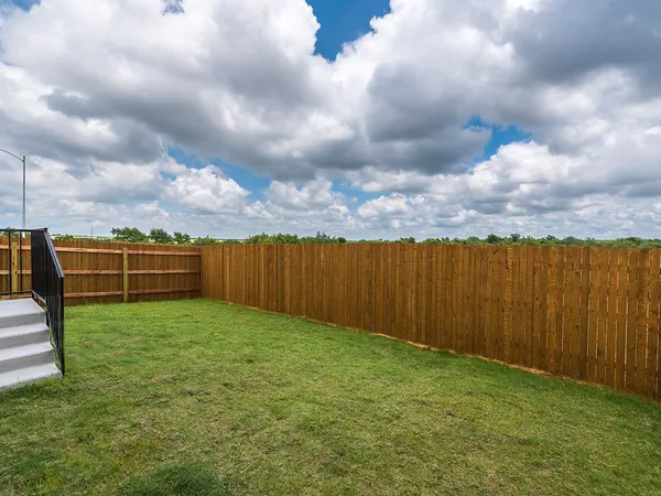 a view of a backyard with wooden fence