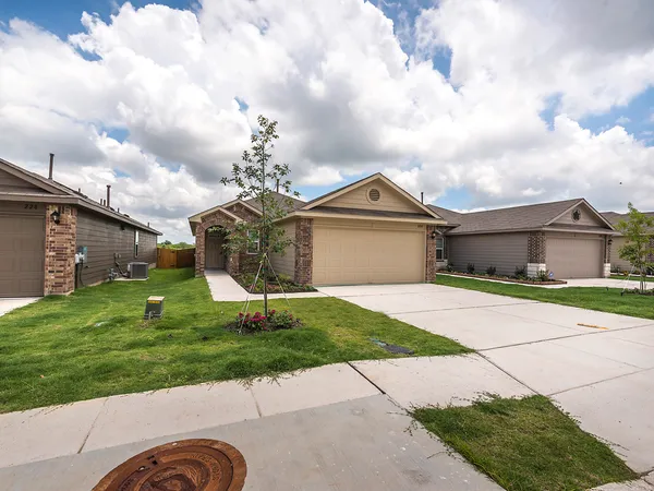 a front view of a house with a garden and trees