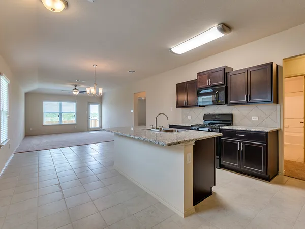 a kitchen with stainless steel appliances granite countertop a sink stove and microwave
