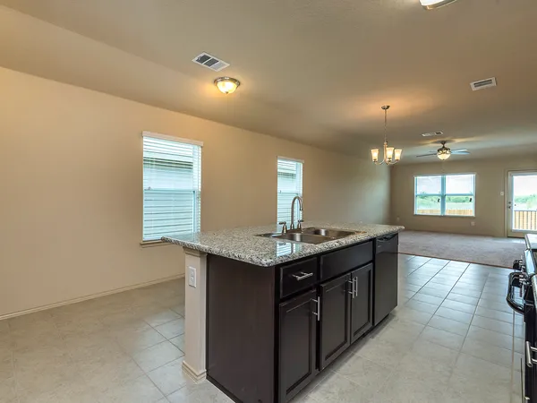 a kitchen with granite countertop a sink and cabinets
