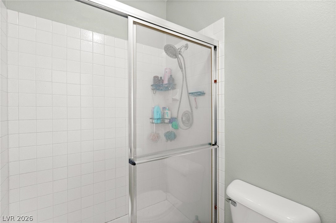 3238 Mystic Ridge Court Las Vegas, NV 89129 - Photo 12 of 31 A well-maintained shower with crisp white tile and a convenient glass enclosure.