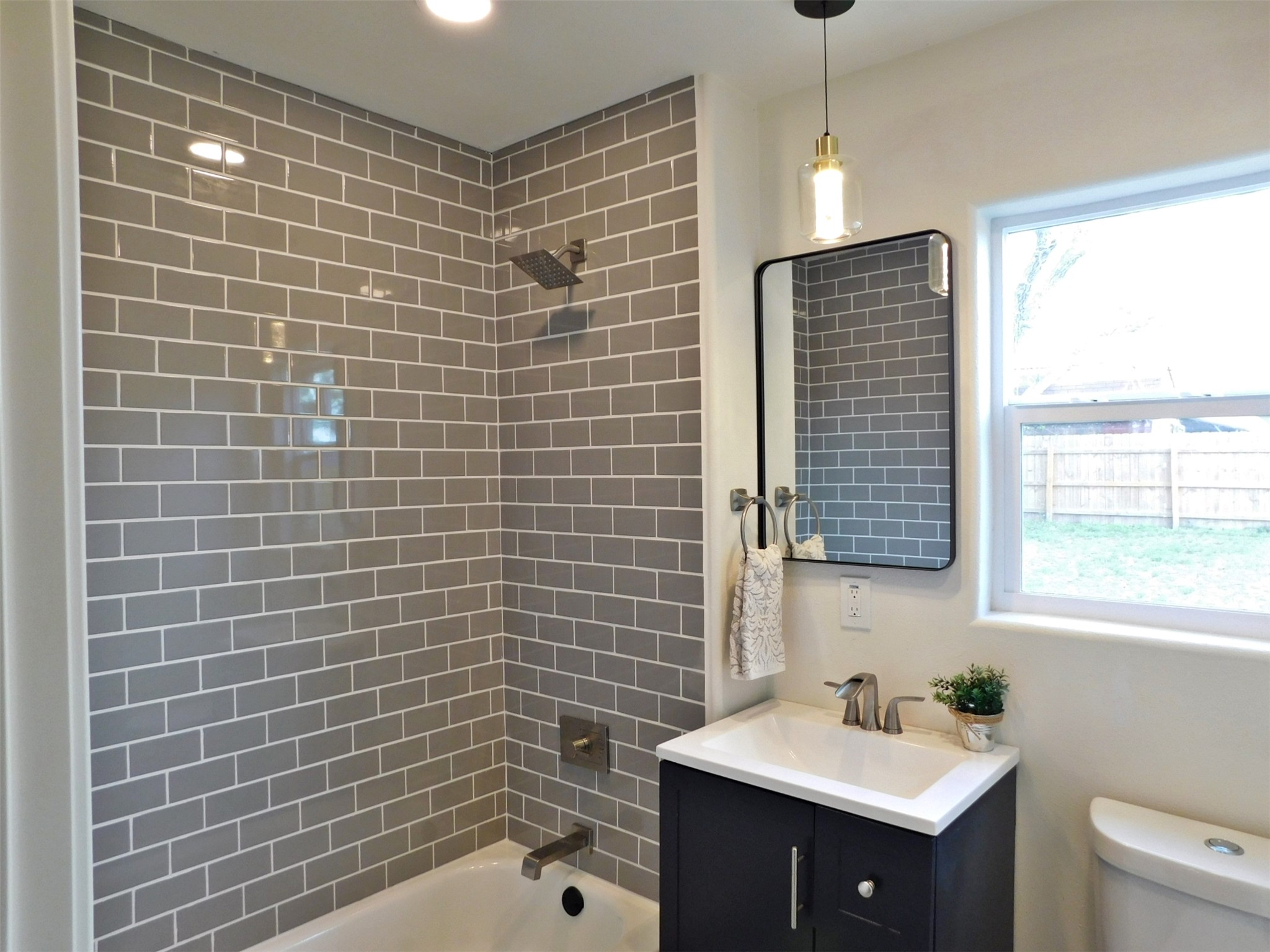205 East Train Street Ellinger, TX 78938 - Photo 17 of 27 a bathroom with a sink a toilet a window and shower