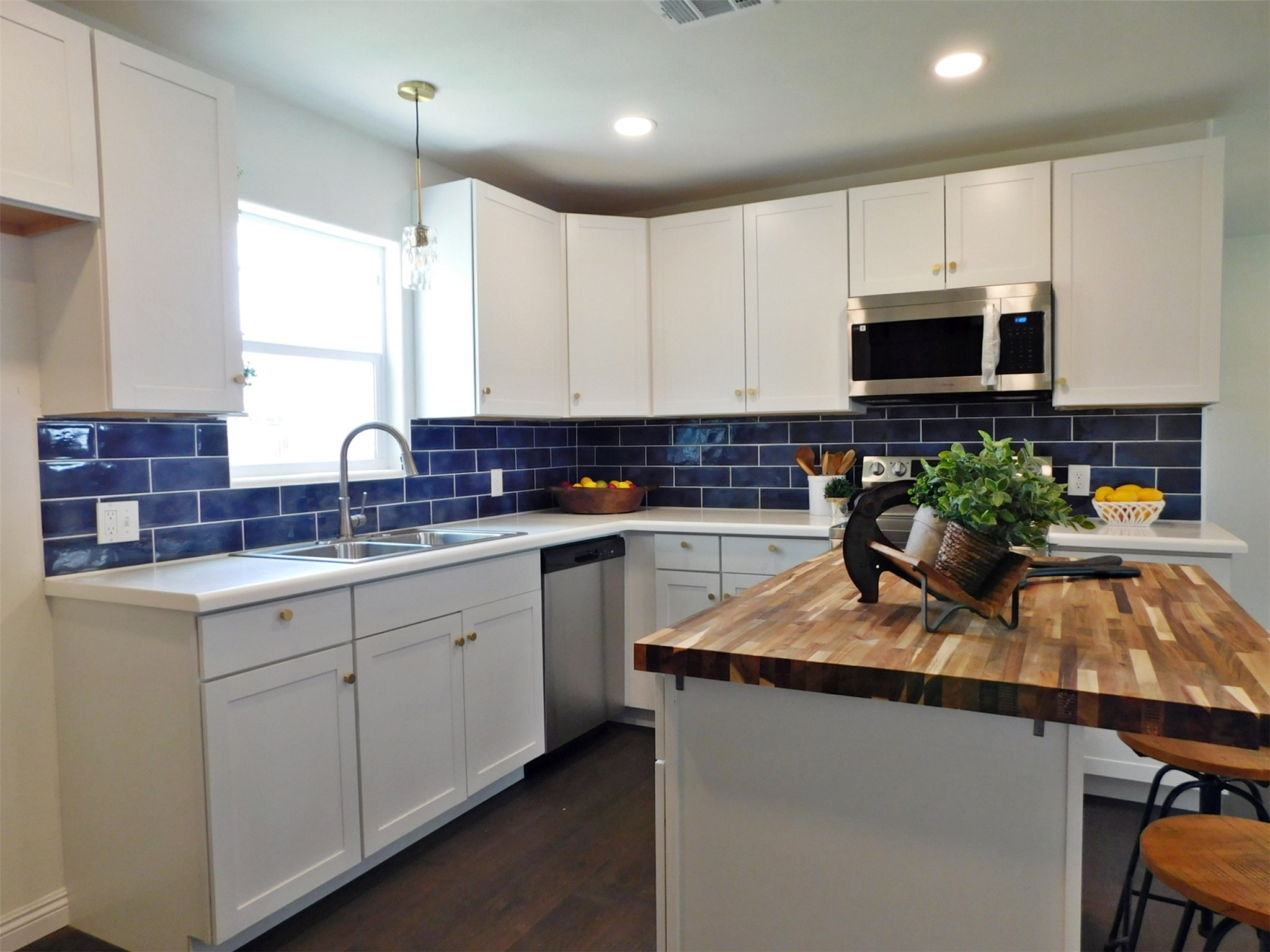205 East Train Street Ellinger, TX 78938 - Photo 10 of 27 a kitchen with stainless steel appliances granite countertop a sink a stove a microwave a refrigerator and cabinets